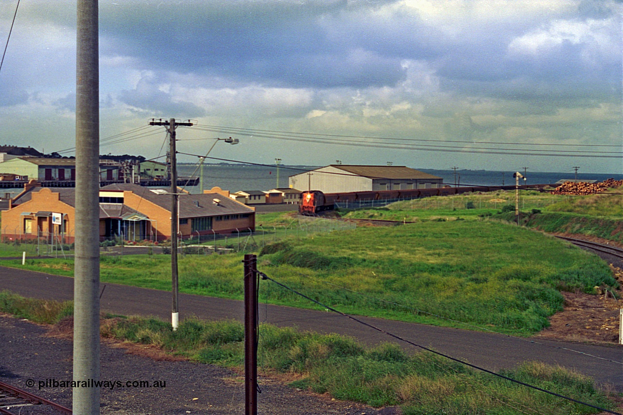 185-08
North Geelong Grain Loop view from Corio Quay Road across to Corio Quay with Access Road and the former tracks to South Quay visible at the left corner, the grain train is approaching the Home Signal that protected the former Freezing Works Siding.
