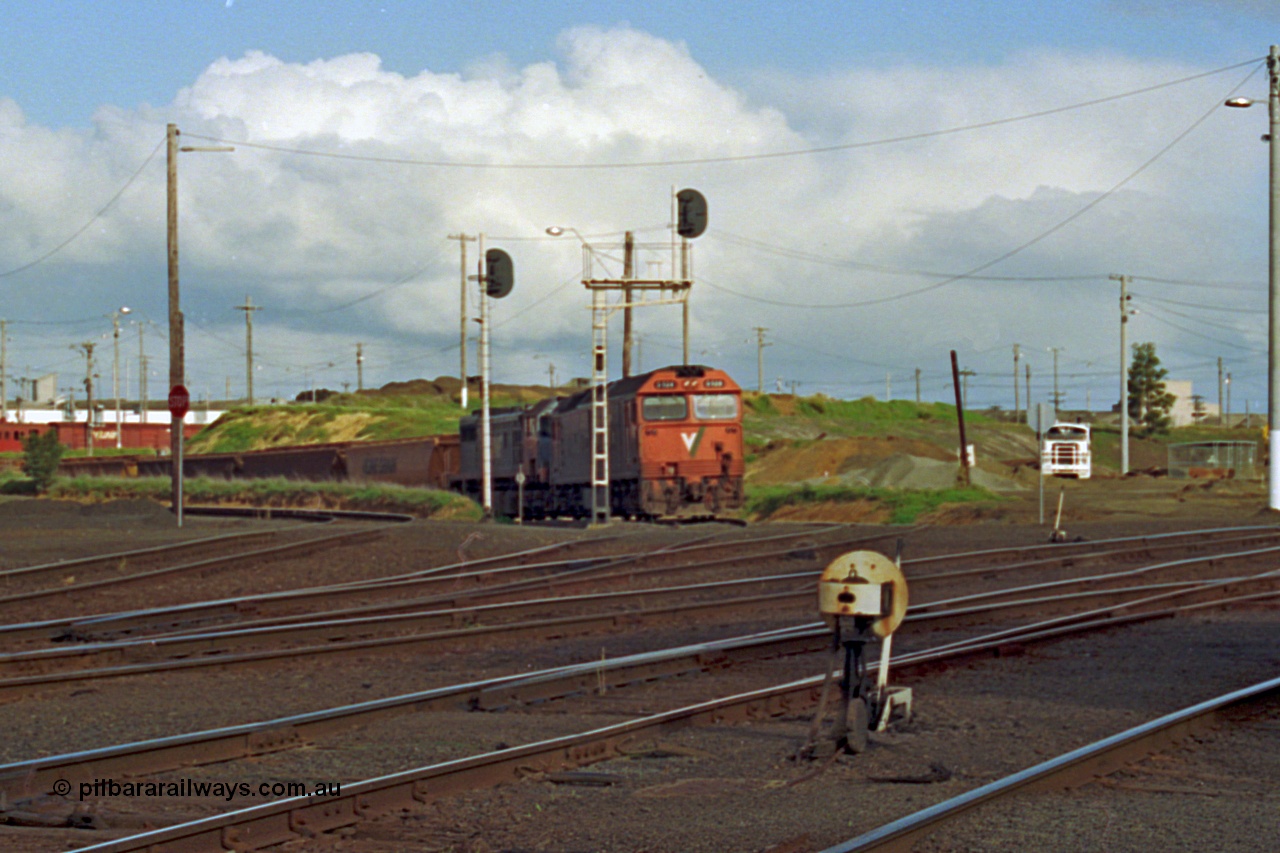 185-23
North Geelong C Box, view of empty grain train returning from the grain loop behind a G class locomotive G 528 Clyde Engineering EMD model JT26C-2SS serial 88-1258 and X class X 41 Clyde Engineering EMD model G26C serial 70-704 as they pass searchlight signal post 19 and 19B, ground dwarf disc signal 18 in the foreground.
Keywords: G-class;G528;Clyde-Engineering-Somerton-Victoria;EMD;JT26C-2SS;88-1258;