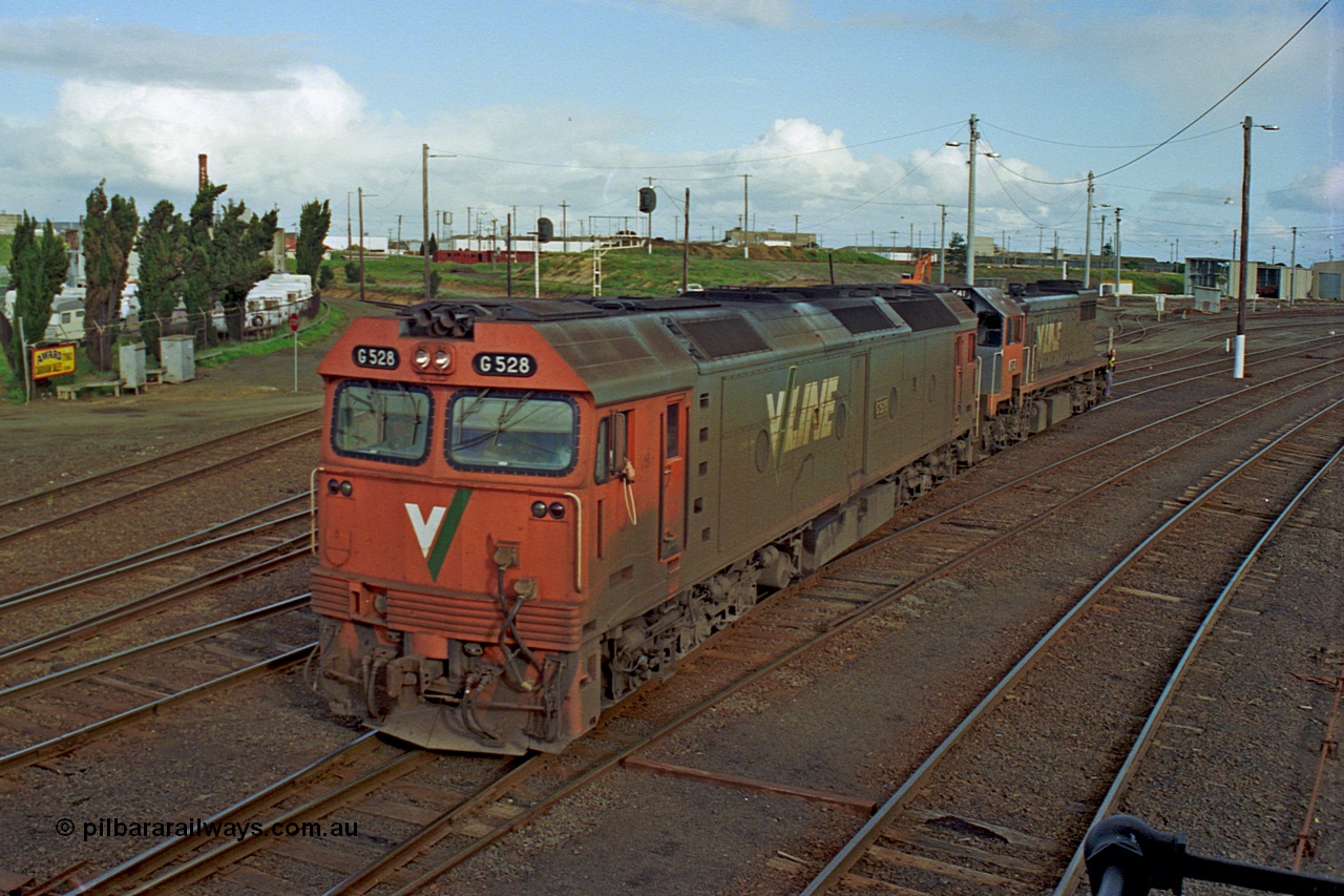 185-29
North Geelong Yard, view from North Geelong C Signal Box of light engines G class G 528 Clyde Engineering EMD model JT26C-2SS serial 88-1258 and X class X 41 Clyde Engineering EMD model G26C serial 70-704 as the driver prepares to surrender the staff for the grain loop.
Keywords: G-class;G528;Clyde-Engineering-Somerton-Victoria;EMD;JT26C-2SS;88-1258;