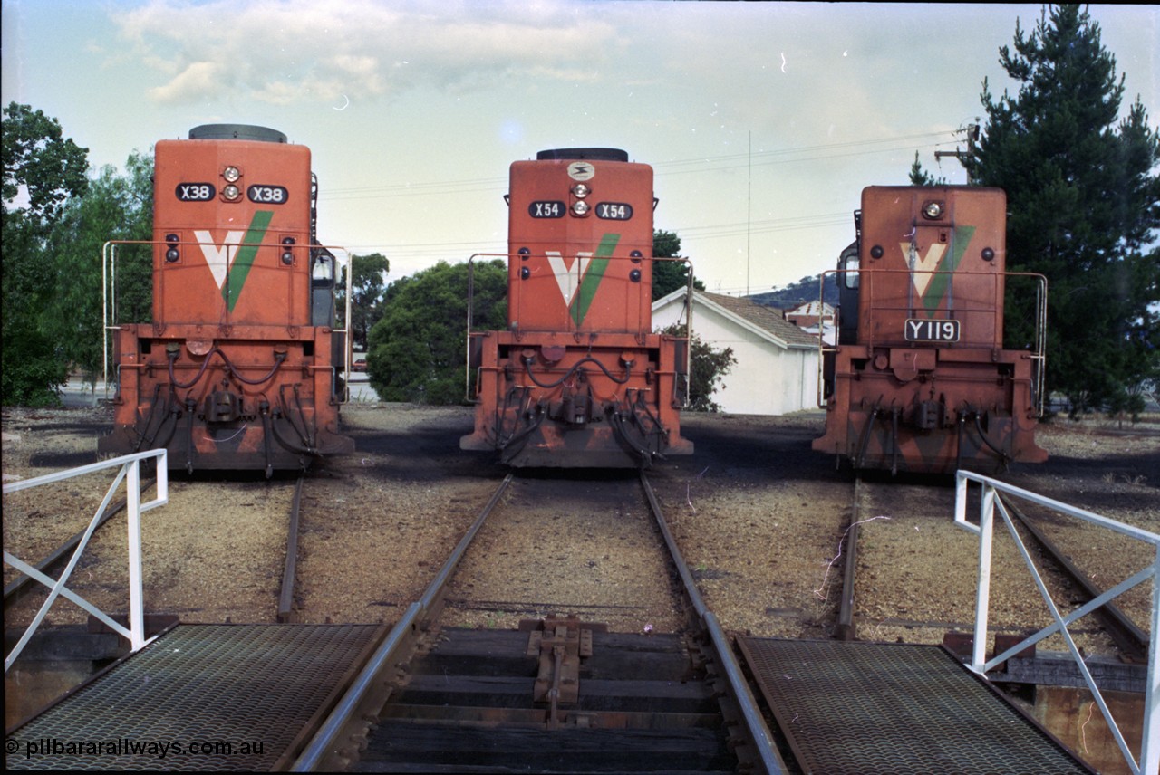 189-34
Wodonga, loco depot turntable radial roads, V/Line broad gauge locos lined up, 2nd series X class X 38 Clyde Engineering EMD model G26C serial 70-701 and 3rd series X class X 54 serial 75-801 with Y class Y 119 Clyde Engineering EMD model G6B serial 63-309, all long hood facing camera.
Keywords: X-class;X54;Clyde-Engineering-Rosewater-SA;EMD;G26C;75-801;