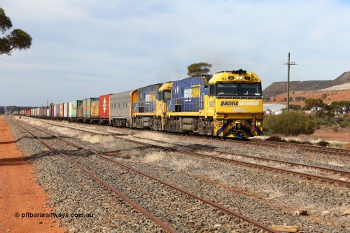 160523 2928
Parkeston, 7SP3 intermodal train, a pair of Goninan built GE model Cv40-9i NR class units NR 12 serial 7250-02/97-214 and NR 51 serial 7250-08/97-253 lead the train 'elephant style' out of the dip and along the mainline at the 1776 km. The PN local is in the car at the gantry performing a roll-by, the track on the left is the Engineers Siding.
Keywords: NR-class;NR12;Goninan;GE;Cv40-9i;7250-02/97-214;