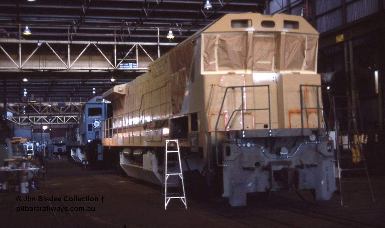 1049 001
Welshpool, Goninan Open Day 27th August, 1988. View of the assembly floor area, brand new GE CM39-8 locomotive 5631 serial 5831-10 / 88-080 under construction for Mt Newman Mining with sister unit 5632 inline behind it.
Jim Bisdee photo.
Keywords: 5631;Goninan;GE;CM39-8;5831-10/88-080;