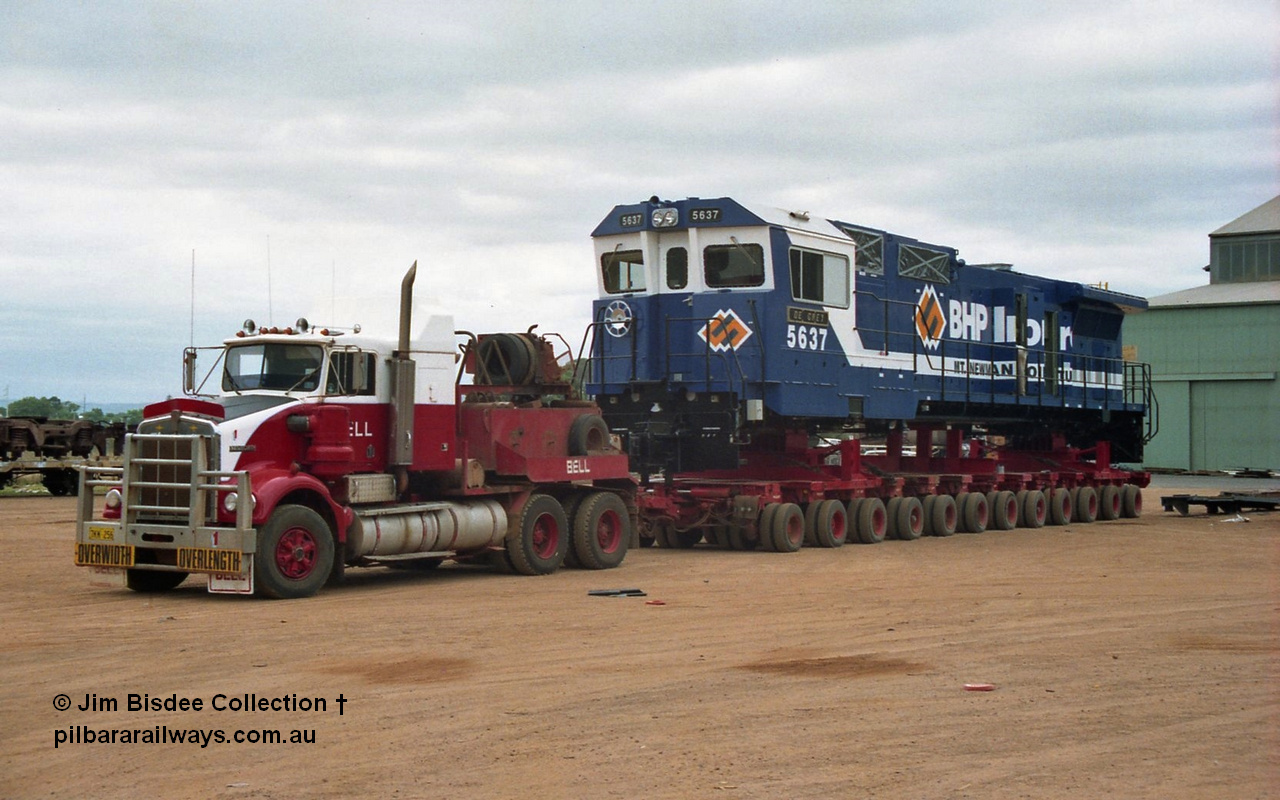 20845
Bassendean, Goninan workshops, newly completed BHP Iron Ore CM40-8M rebuild unit 5637 'De Grey' serial 8181-01 / 92-123 sits on a Bell road transport float with a Kenworth SAR bound for Port Hedland. 5637 was rebuilt from AE Goodwin ALCo C636 unit 5456 serial G6012-5. January 1992 image.
Jim Bisdee photo.
Keywords: 5637;Goninan;GE;CM40-8M;8181-01/92-123;rebuild;AE-Goodwin;ALCo;C636;5456;G6012-5;