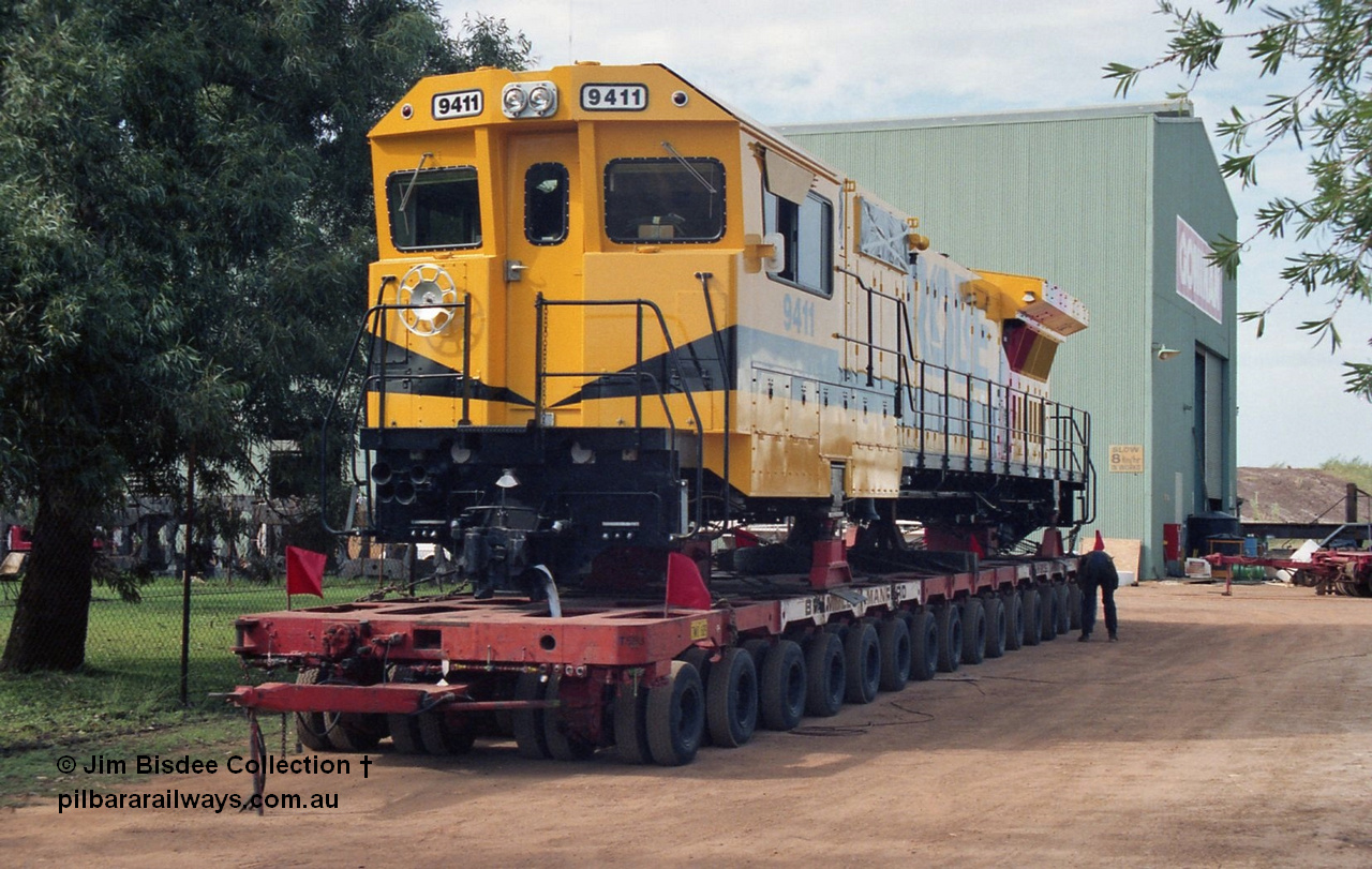 20956
Bassendean, Goninan workshops, sitting outside the gates waiting to head to Cape Lambert, Robe River Goninan GE CM40-8M rebuild unit 9411 serial 8206-02 / 92-125, retains its original Robe River road number on a hundred and twenty wheel road float. 9411 was rebuilt into the GE CM40-8M unit from AE Goodwin ALCo M636 serial G6060-2. February 1992.
Jim Bisdee photo.
Keywords: 9411;Goninan;GE;CM40-8M;8206-02/92-125;rebuild;AE-Goodwin;ALCo;M636;G6060-2;