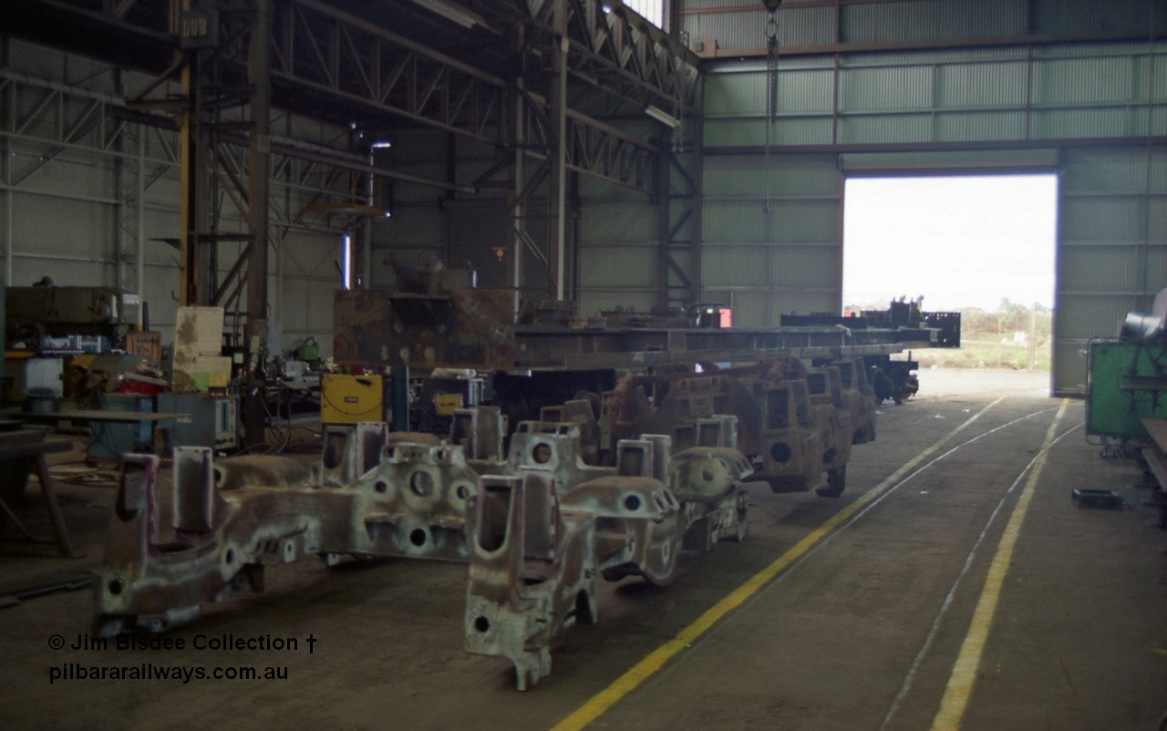 22658
Bassendean, during an Open Day at the Goninan workshops, a stripped back ALCo locomotive frame under re-construction which will become a GE CM40-8M in the background and the two types of bogie which rode under the Mt Newman Mining ALCo units, in front is the ALCo Hi-Ad truck and behind is the MLW Dofasco truck. 20th July 1991.
Jim Bisdee photo.
