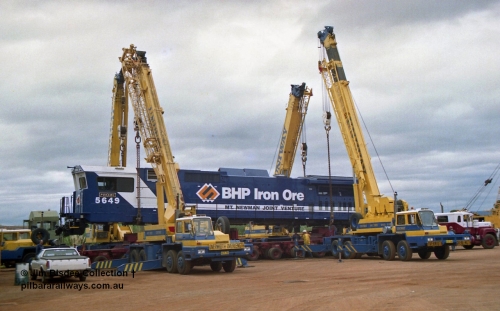 23884
Bassendean, Goninan workshops, BHP Iron Ore GE CM40-8M rebuild unit 5649 'Pohang' serial 8412-07 / 93-140 is lifted up with the Bell road transport float being prepped underneath for road haulage to Port Hedland. 5649 was rebuilt from AE Goodwin ALCo M636 unit 5473 serial G6047-5. July 1993.
Jim Bisdee photo.
Keywords: 5649;Goninan;GE;CM40-8M;8412-07/93-140;rebuild;AE-Goodwin;ALCo;M636C;5473;G6047-5;