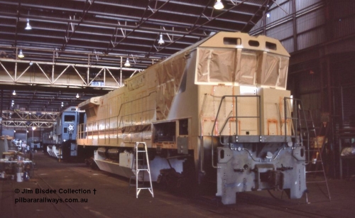 6983 001
Welshpool, Goninan Open Day 27th August, 1988. View of the assembly floor area, brand new GE CM39-8 locomotive 5631 serial 5831-10 / 88-080 under construction for Mt Newman Mining masked up ready for painting with sister unit 5632 inline behind it.
Jim Bisdee photo.
Keywords: 5631;Goninan;GE;CM39-8;5831-10/88-080;