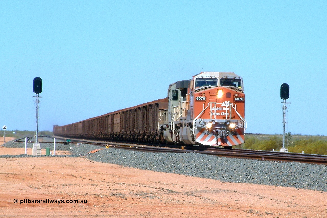 040508 113001r
Mooka Siding, BHP Billiton GE AC6000 6075 'Newman' serial 51067 and EMD SD40-2 3082 serial 786263-31 originally Union Pacific UP 3639 split the north end departure signals with a 300 waggon loaded train, the first pair of mid-train units 5633-5663 are visible, trailing are 5658-5631 and end of the train can be seen on the right. 8th May 2004.
Keywords: 6075;GE;AC6000;51067;