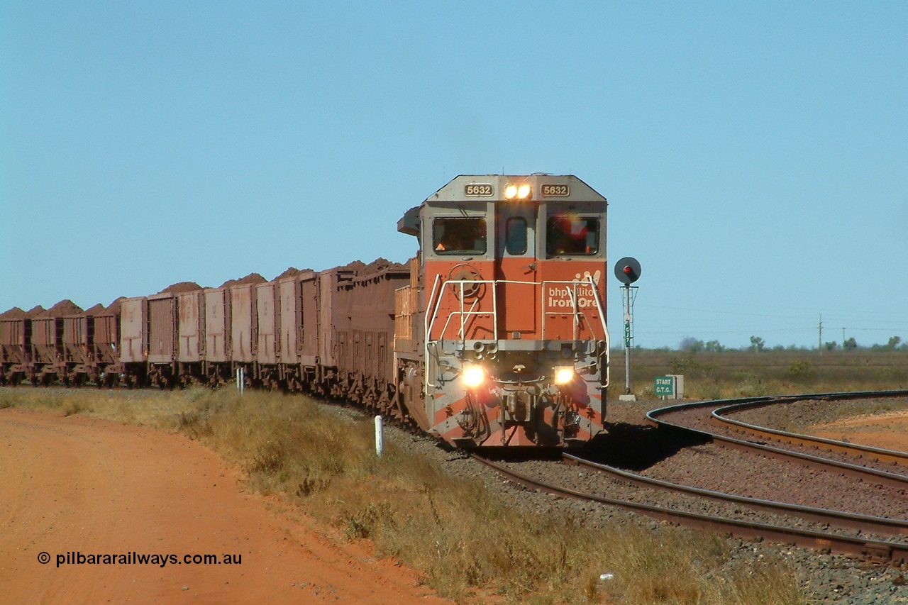 040802 141058r
Goldsworthy Junction, BHP Billiton Goninan GE built CM39-8 5632 'Poseidon' serial 5831-11 / 88-081 in charge of the 'Recycle Rake' is traversing the Transfer Road, this train conveys ore from Nelson Point to Finucane Island, sometimes twice a day. The line to the right is the line to the Junction, Yarrie and Bing. 1410 hrs 2nd August 2004.
Keywords: 5632;Goninan;GE;CM39-8;5831-11/88-081;