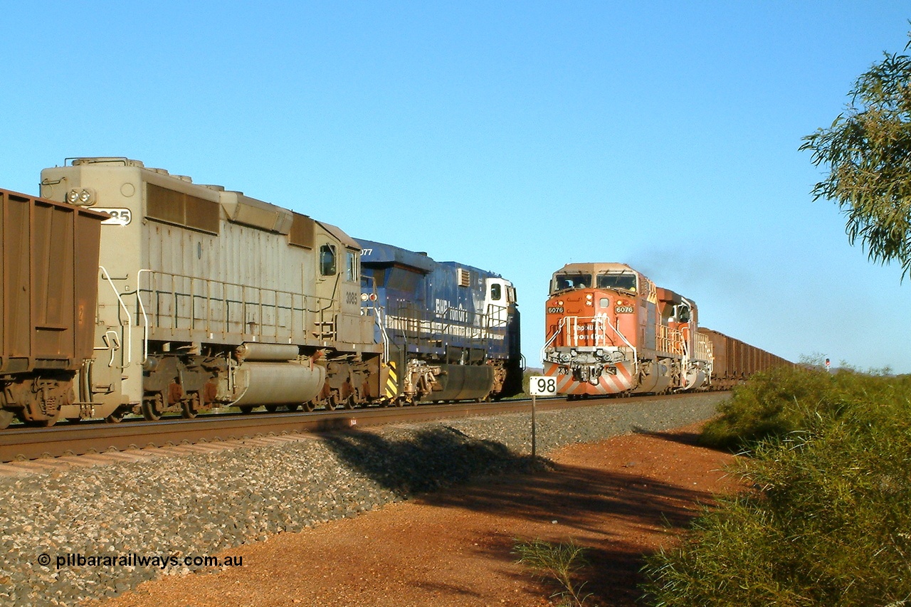 040810 165626r
Gillam Siding BHP Billiton GE AC6000 6076 'Mt Goldsworthy' serial 51068 leads an all bubble paint quin consist on the main with EMD SD40R 3091 serial 31496 originally Southern Pacific SD40 SP 8415 and mid-train units CM40-8M 5636 leading newly delivered SD40R units 3095 and 3096 as they cross an empty headed up by GE AC6000 6077 'Nimingarra' serial 51069 and EMD SD40-2 3085 serial 786170-25 and originally Union Pacific UP 3523. 10th August 2004.
Keywords: 6076;GE;AC6000;51068;