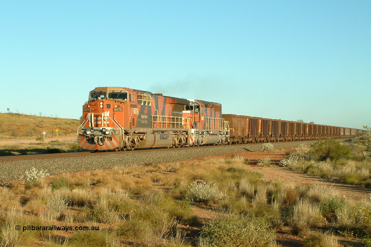 040810 171258r
At the 76 km grade crossing BHP Billiton GE AC6000 6076 'Mt Goldsworthy' serial 51068 leads an all bubble paint quin consist on the main with EMD SD40R 3091 serial 31496 originally Southern Pacific SD40 SP 8415 and mid train units CM40-8M 5636 leading newly delivered SD40R units 3095 and 3096. This crossing has been moved since Tabba Siding was built in this location. 10th August 2004.
Keywords: 6076;GE;AC6000;51068;