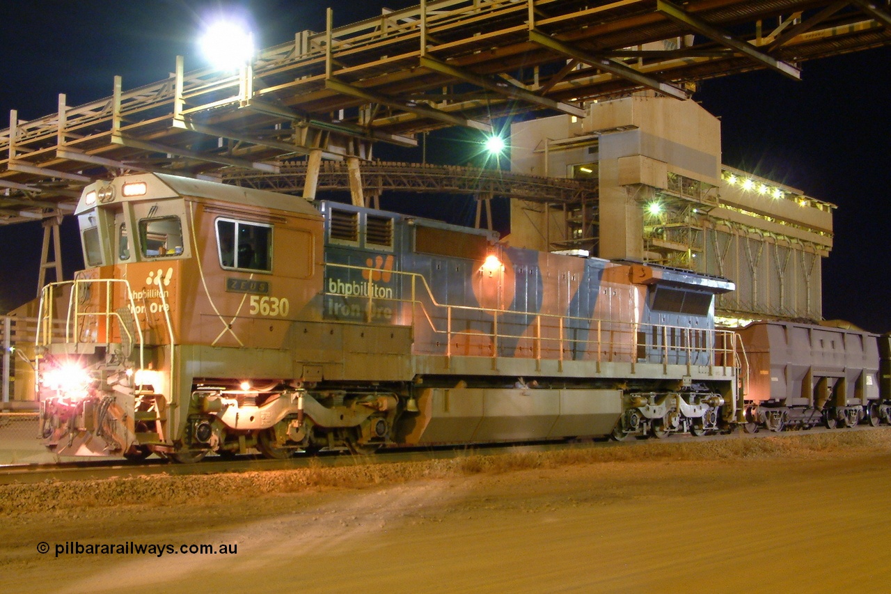 040817 194500r
Nelson Point, BHP Billiton Goninan GE CM39-8 unit 5630 'Zeus' serial 5831-09 / 88-079 class leader of a batch of four new built units, 5630 ended up travelling 4,940,000 km when retired. Here it idles away next to TSB 2 building awaiting a path out of Nelson Point yard with the 'Recycle Rake' bound for the dumper at Finucane Island 1945 hrs 17th August 2004.
Keywords: 5630;Goninan;GE;CM39-8;5831-09/88-079;