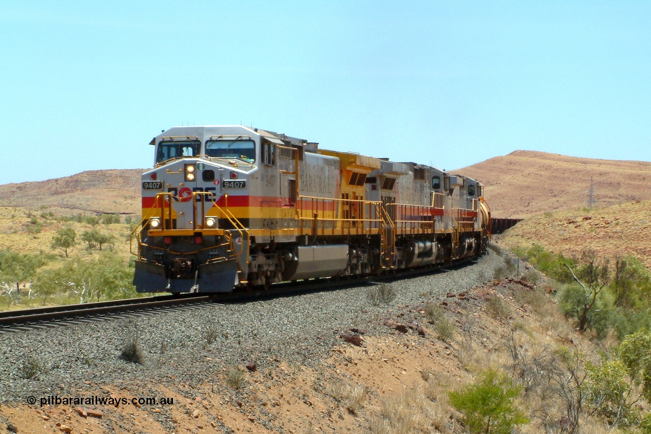 050110 120842r
North of Maitland Siding on the Deepdale line at the 83.7 km grade crossing, Robe River owned General Electric Dash 9-44CW unit 9407 serial 54157 in Pilbara Rail livery leads a pair of Hamersley Iron owned and liveried sister units 7075 serial 47754 and 7067 serial 47746 with an empty working for the Deepdale or Mesa J mine on the Robe River line with three loaded fuel tank waggons trailing the locos. Monday 10th January 2005.
Keywords: 9407;GE;Dash-9-44CW;54157;