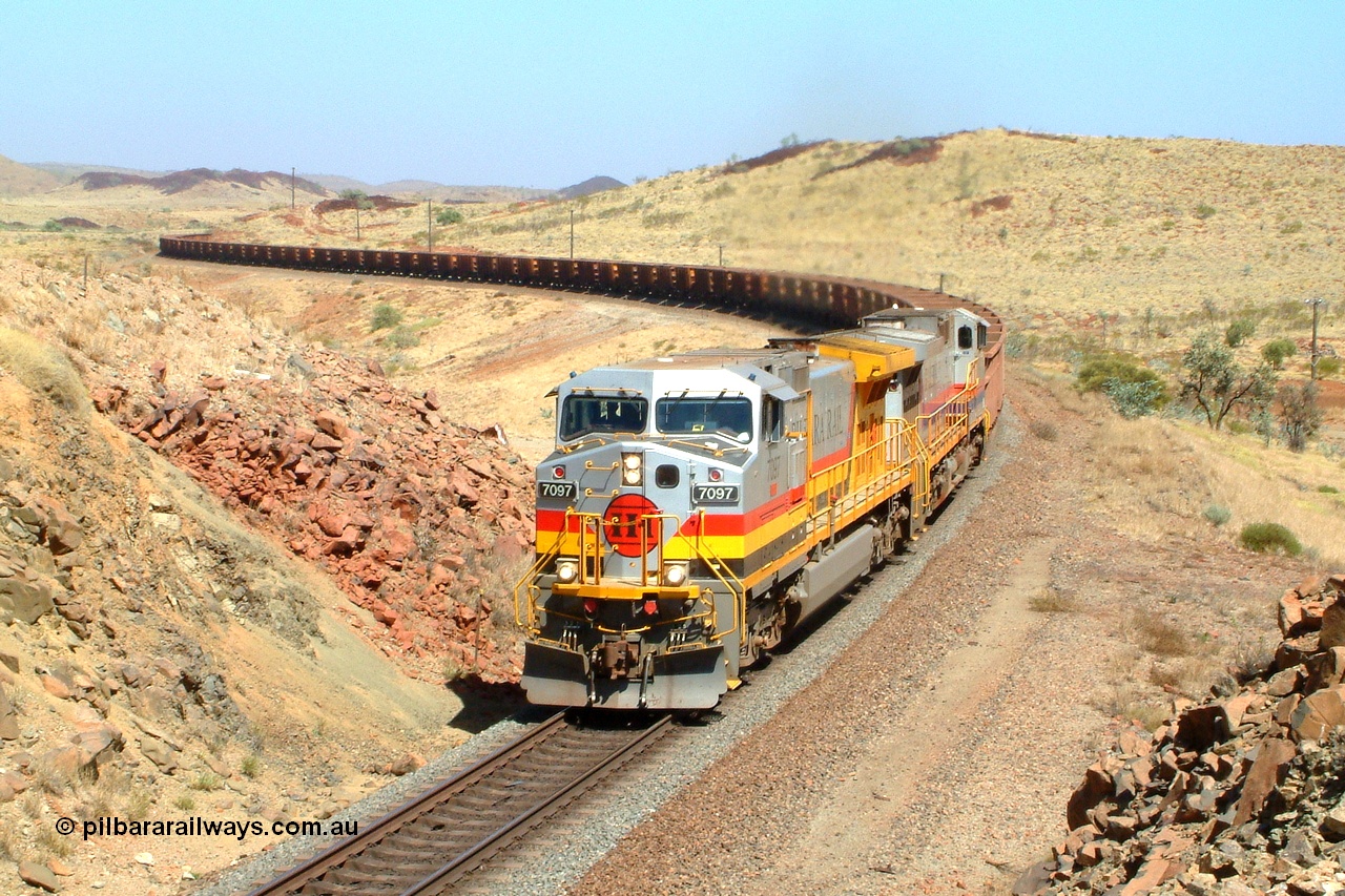 050111 095514r
Dugite Siding, Hamersley Iron owned Pilbara Rail's only named General Electric built Dash 9-44CW locomotive 7097 'Ken Onley' serial 54160 leads sister unit 7093 serial 47772 the final unit of the original order in original livery as they climb the range near the 67 km with an empty working on the Dampier mainline. Tuesday 11th January 2005.
Keywords: 7097;GE;Dash-9-44CW;54160;