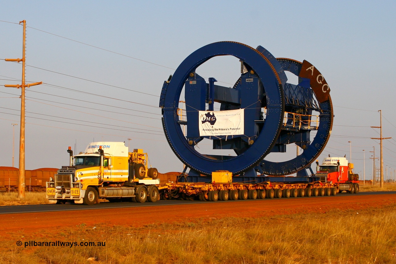 070923 1044r
Port Hedland, Wilson Street, two Kingston Mack prime movers power the 256 wheel float with the second Metso built rotary dumper cell for FMG. Seen here approaching the Redbank Bridge. Of note is these cells for FMG will clamp the top of the ore waggon, similar to the Pilbara Iron dumpers, while the BHP cells clamp down on side pockets in the waggons. Sunday 23rd September 2007.
