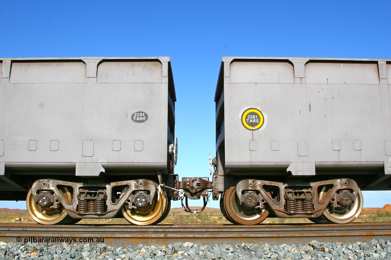 080116 1375r
Chapman Siding, view of FMG's Zhuzhou Rolling Stock Works built waggons showing the 'F' type fixed and rotary couplers between 'control' waggon 2396 and 'slave' waggon 1187. Note the difference in the tare weights, 2396 with the fixed coupler is the 'control' waggon, while 1187 is the 'slave' waggon with the rotary coupler. The yellow circle also denotes the rotary coupler end. 16th January 2008.
Keywords: CSR-Zhuzhou-Rolling-Stock-Works-China;