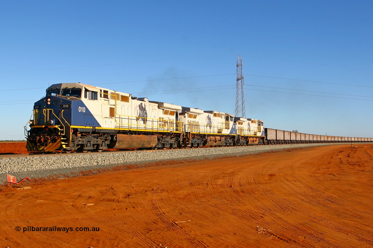 080525 2325r
Boodarie, Great Northern Highway grade crossing sees FMG General Electric built Dash 9-44CW locomotive 010 serial 58187 leading sisters 012 serial 58189 and 003 serial 58180 with an empty train heading for Cloud Break mine. The very top of the failed BHP Billiton HBI plant can be seen over the fourth and fifth ore waggons. 25th May 2008.
Keywords: FMG-010;GE;Dash-9-44CW;58187;