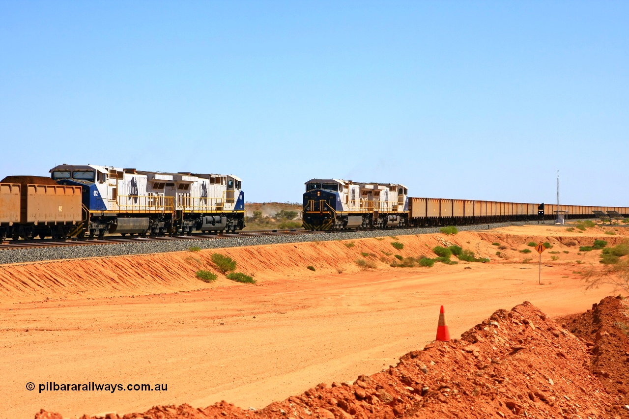 090814 2109r
Hunter Siding, the empty train takes the passing track under the power of two FMG General Electric built Dash 9-44CW units 011 serial 58188 and 010 serial 58187, while another pair of identical units 002 serial 58179 and 012 serial 58189 hold the mainline and will wait for a new PA to continue towards the port. The dust between the two trains is from the BHP access road. 14th August 2009.
Keywords: FMG-011;GE;Dash-9-44CW;58188;