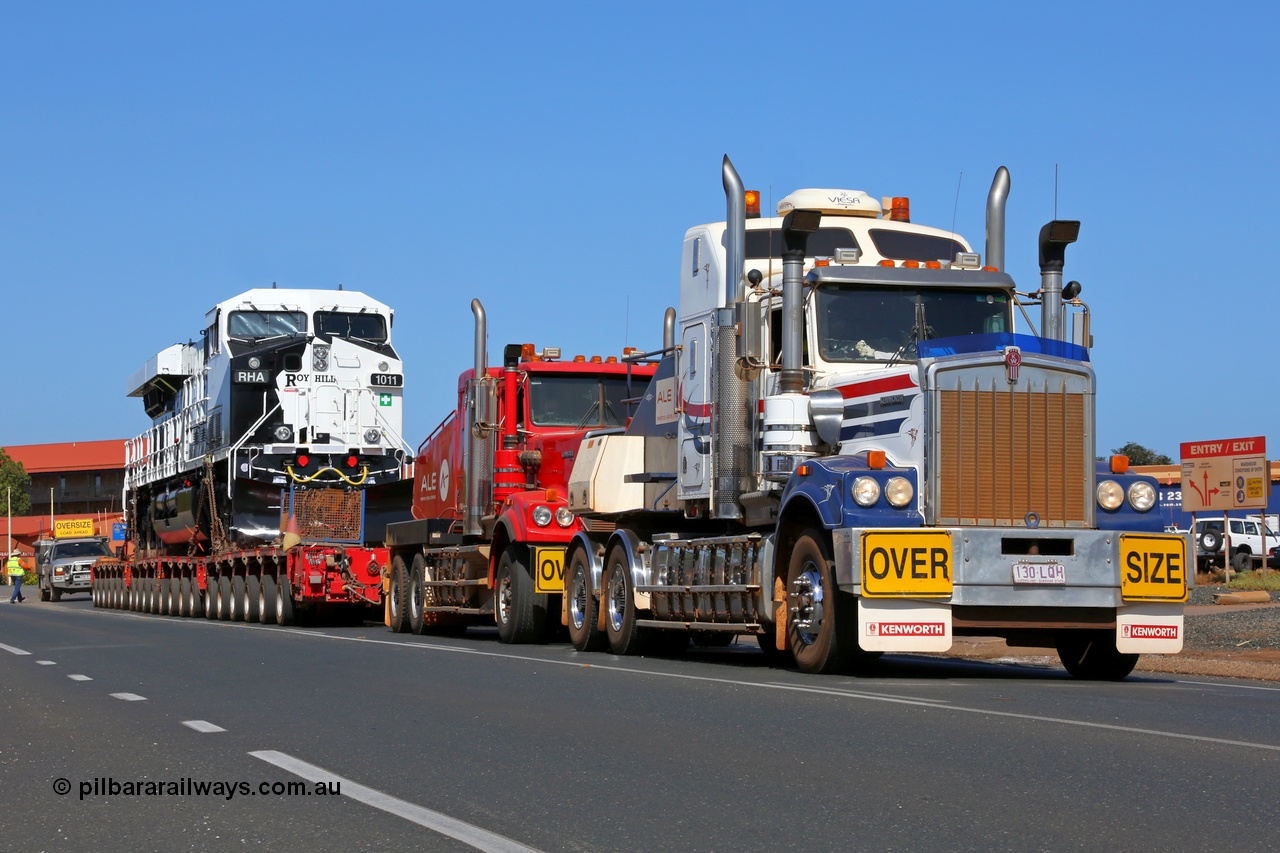 150130 7570
Port Hedland, Wilson Street, now with the second ALE Kenworth prime mover coupled up Roy Hill's General Electric built ES44ACi unit RHA 1011 serial 62583 heads off to be placed on rails. 30th January 2015.
Keywords: RHA-class;RHA1011;GE;ES44ACi;62583;