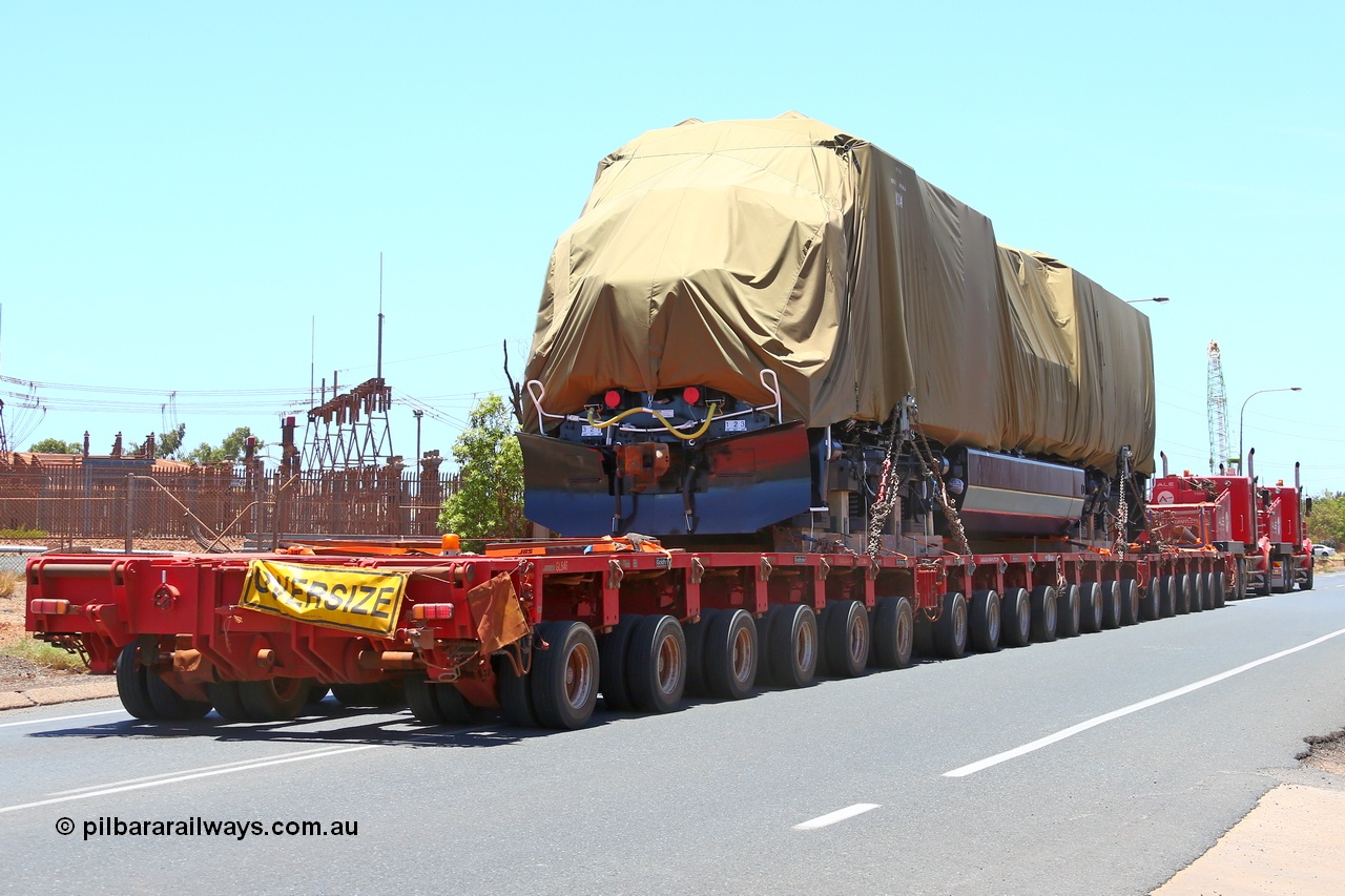 150131 7693
Port Hedland, Wilson Street, view of Roy Hill's General Electric built ES44ACi unit RHA 1014 serial 62586 still under tarp during delivery behind dual ALE Kenworth prime movers. 31st January 2015.
Keywords: RHA-class;RHA1014;GE;ES44ACi;62586;