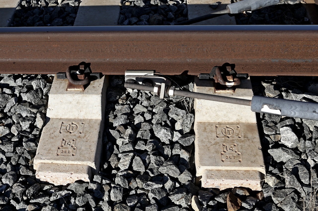 180701 9484r
Roy Hill track formation near the 63 km. Sleepers are moulded IT for Italian Thai DPC Ltd of Thailand who manufactured them, 14 for year of manufacture and then a serial number. The rail is moulded 136 10 VT NIPPON 2014 4 which translates to 136 Ib/yard (or 68 kg/m), 10 for Low Alloy, VT for processes of hydrogen elimination as Vacuum Treated, NIPPON is the manufacturer Nippon Steel, Japan, 2014 year rolled and 4 is month rolled.
